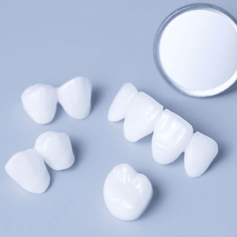 Dental crowns and porcelain veneers displayed with shade guide for cosmetic dentistry in Paradise Valley.