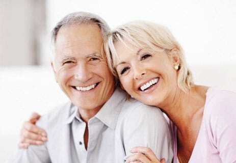 Happy mature couple smiling together, representing positive dental outcomes and patient satisfaction.