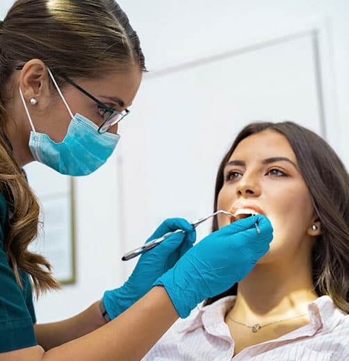 Dentist examining patient's teeth during oral exam in Paradise Valley dental office.