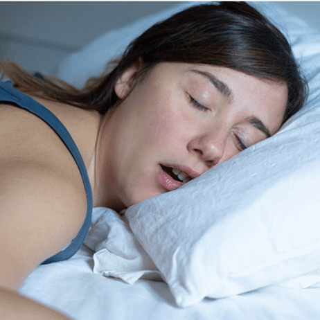 Woman sleeping peacefully on white pillow, representing restorative sleep benefits in Paradise Valley, AZ.