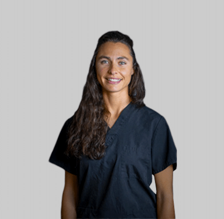 Female dental professional smiling in dark scrubs at Paradise Valley, AZ dental practice.