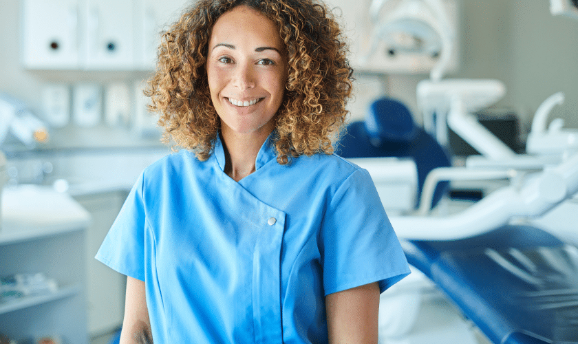 Smiling female dental hygienist in blue scrubs at Paradise Valley dental practice.