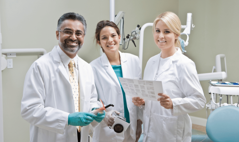 Three dental professionals review x-rays in a Paradise Valley dental treatment room.