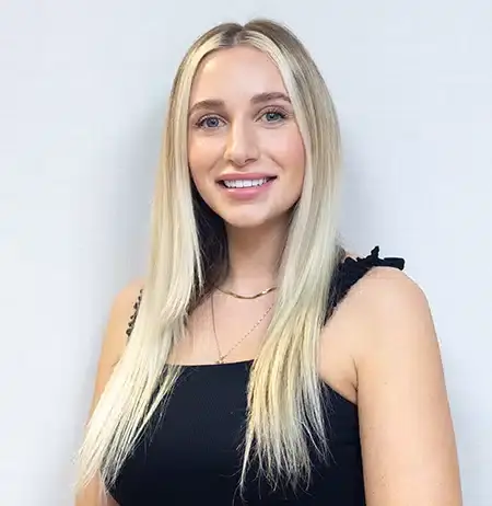 Professional headshot of a smiling woman with long blonde hair wearing black at Paradise Valley dental practice.