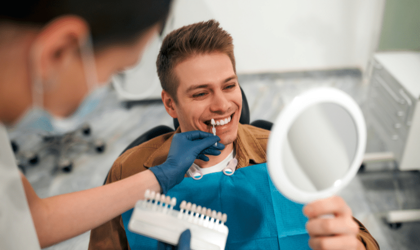 Smiling male patient receiving shade matching for teeth whitening at Paradise Valley dental practice.