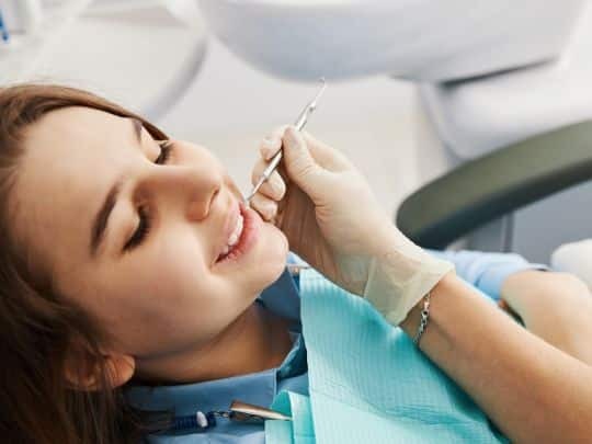 Dentist applying dental filling to patient's tooth during treatment in Paradise Valley.