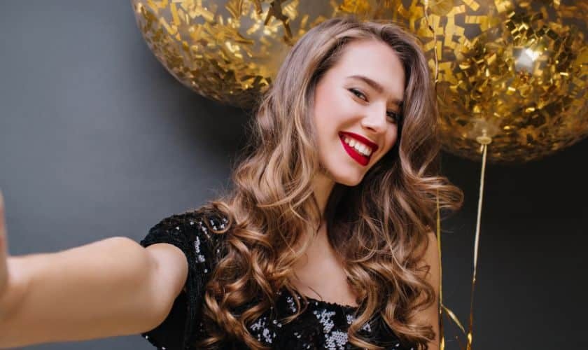 Woman with bright smile and red lipstick celebrating new year dental health goals.