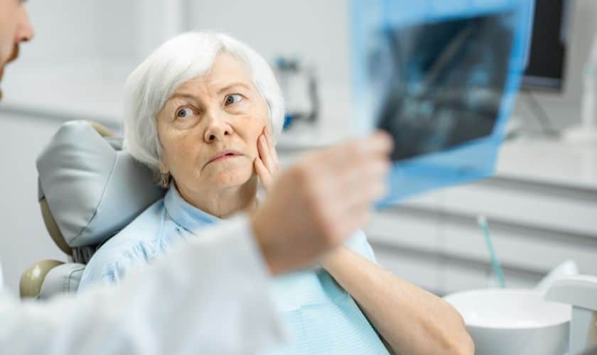 Senior patient reviewing dental X-ray with dentist in Paradise Valley dental office.