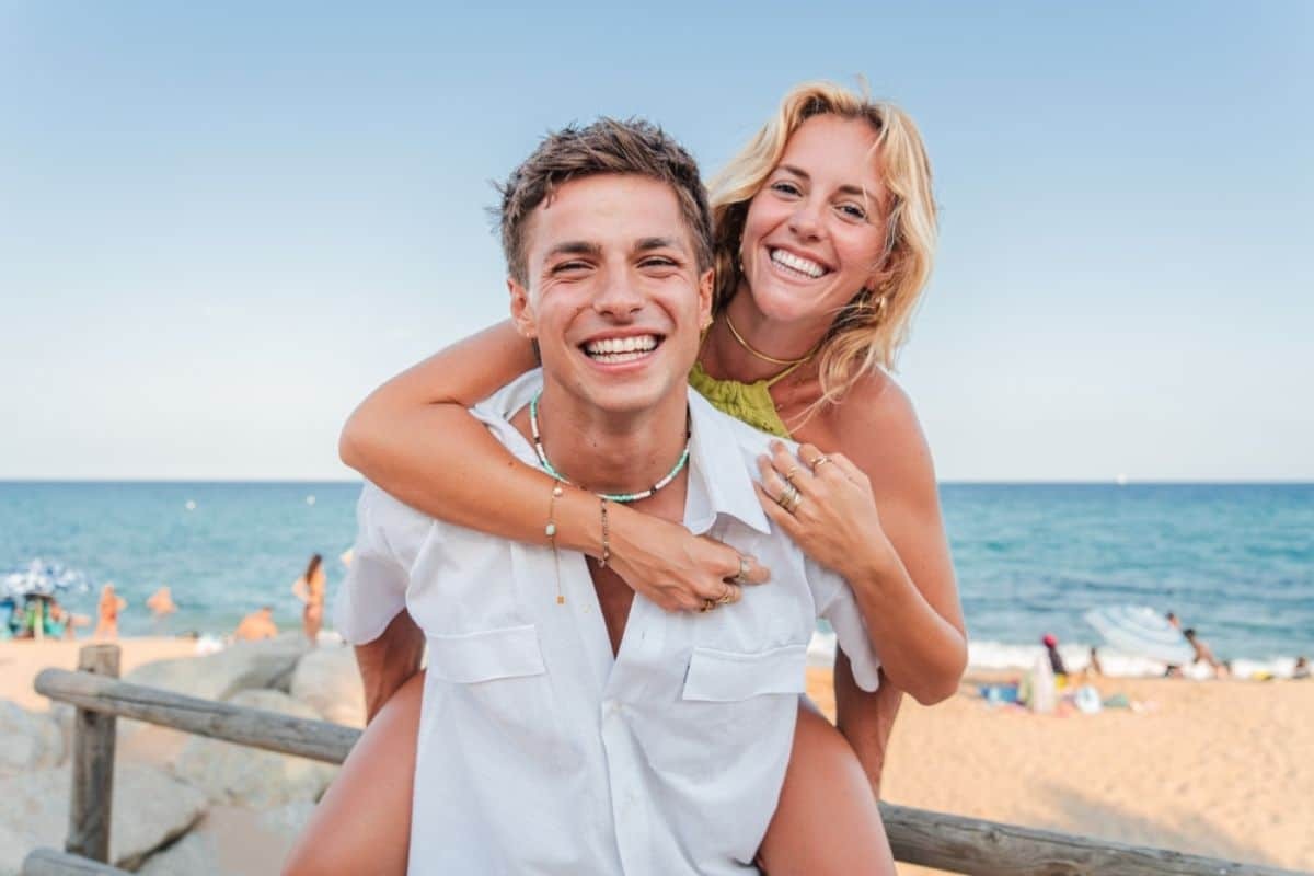 Happy couple enjoying a beach day, showcasing bright, confident smiles.