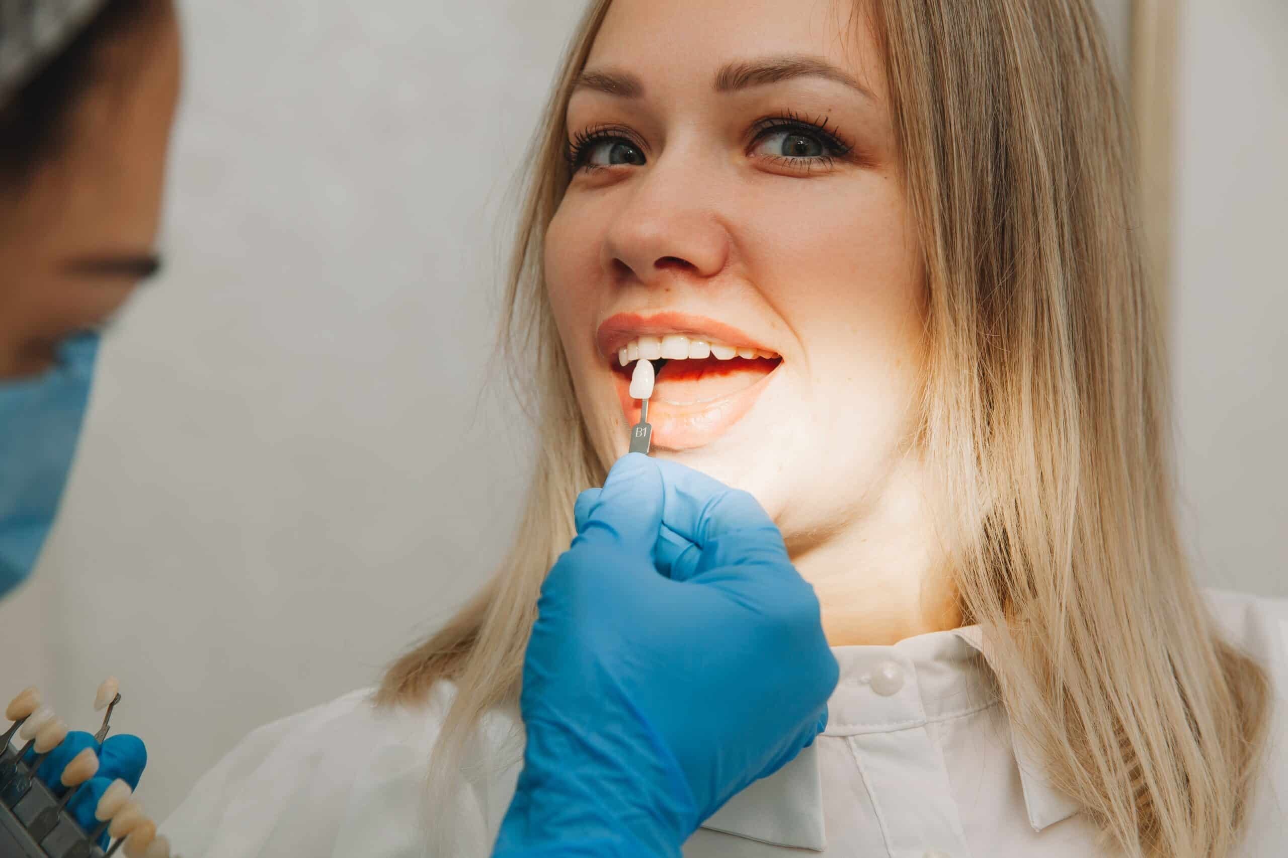 Dentist examining patient's tooth shade during porcelain veneer consultation in Paradise Valley.