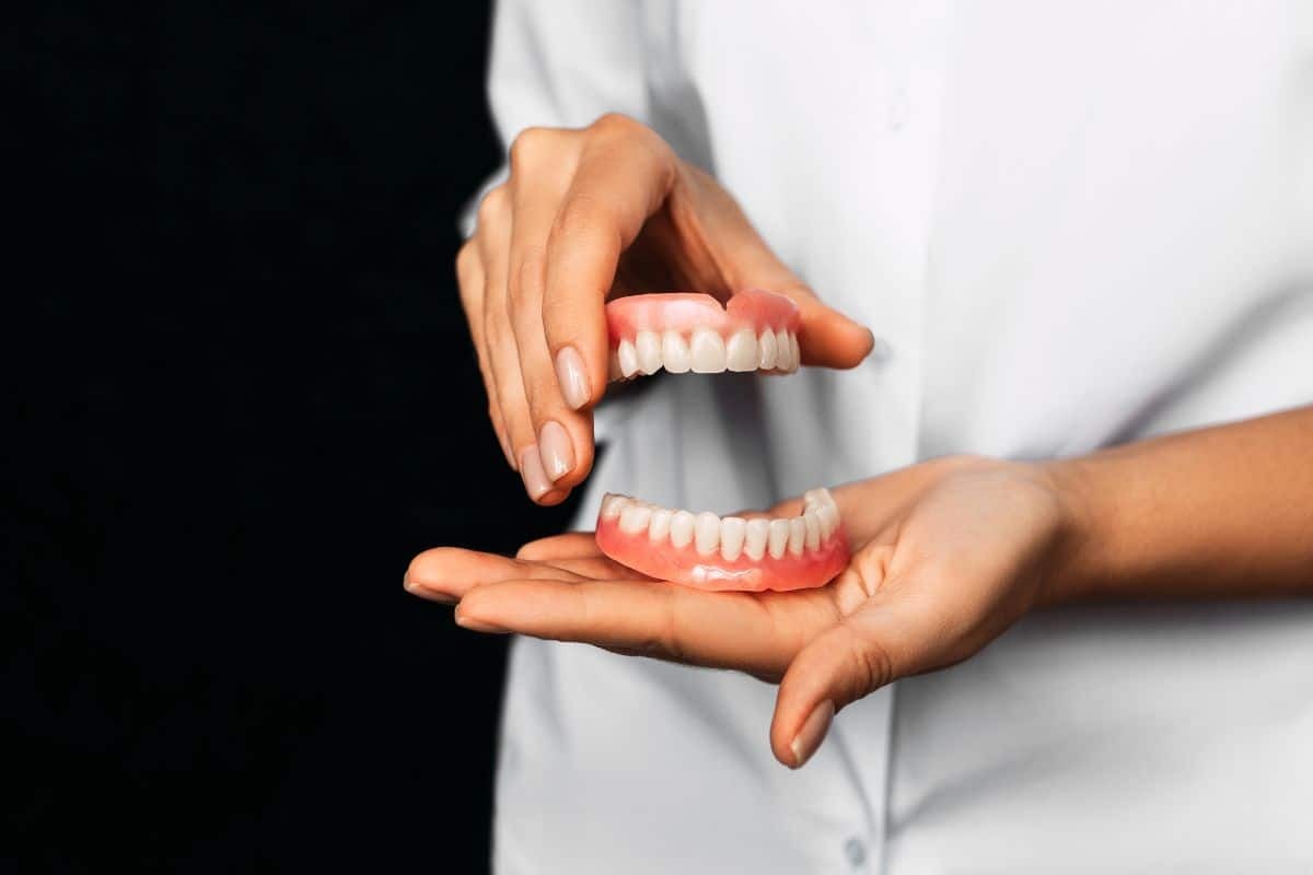 Dentist demonstrating upper and lower dentures to patient with sensitive gums in Paradise Valley.